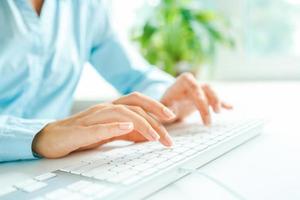 Woman office worker typing on the keyboard photo