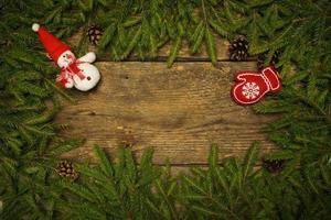 Christmas border with fir tree branches, cones and christmas decorations on wooden boards ready for your design photo