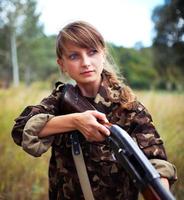 Young beautiful girl with a shotgun photo