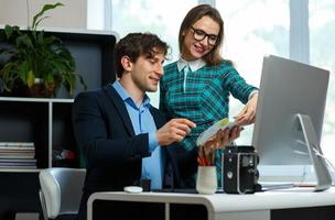 Young colleague - man and woman working from home - modern business concept photo