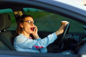 Businesswoman multitasking while driving photo