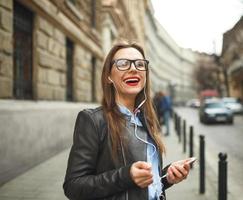 mujer de negocios caminando abajo el calle mientras hablando en inteligente teléfono foto