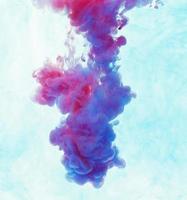 Color drop underwater creating a silk drapery. Ink swirling underwater photo