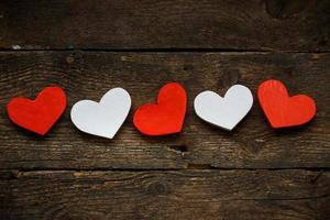 Red and white hearts on old wooden background photo