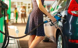 Woman fills petrol into her car photo