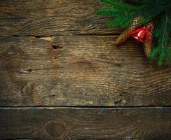 Christmas tree branches with cones and christmas decorations on wooden texture ready for your design photo