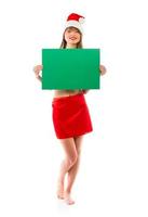 Smiling christmas girl with green placard on white photo