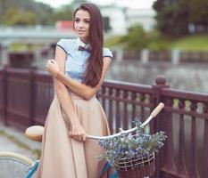 Young beautiful, elegantly dressed woman with bicycle photo