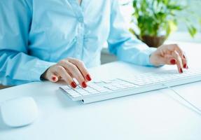 Woman office worker typing on the keyboard photo