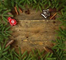 Christmas tree branch with cones, cinnamon, dittany and christmas decorations on wooden background with copyspace photo