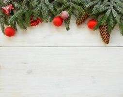 Christmas tree branches with cones, christmas decorations on white wooden texture ready for your design. Winter holidays background photo