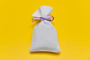 Small white sack isolated on yellow background photo