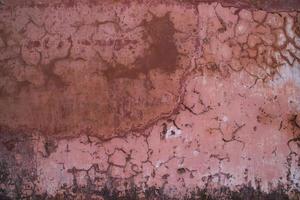 The texture of an old rustic wall is covered with pink stucco photo