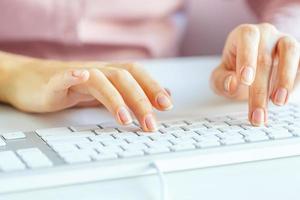 Woman office worker typing on the keyboard photo