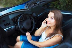 caucásico mujer hablando en teléfono en un cabriolé coche foto