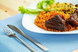 Dish of roast beef with rice and salad leaves photo