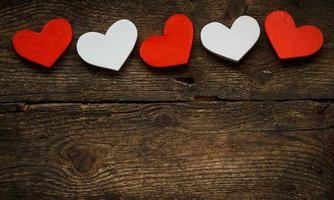 Red and white hearts on old wooden background photo