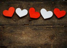 Red and white hearts on old shabby wooden background photo