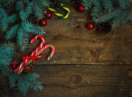 Navidad frontera con abeto árbol, conos, Navidad decoraciones y caramelo caña en de madera tableros foto