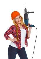 Female construction worker in a helmet with a perforator photo