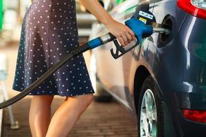 Woman fills petrol into her car photo