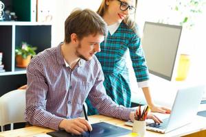 Beautiful young woman and man working from home office photo