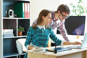 Beautiful young woman and man working from home office photo