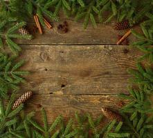 Christmas tree branch with cinnamon sticks and dittany on wooden texture with copyspace photo