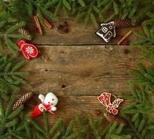 Navidad árbol rama con conos, canela, díctamo y Navidad decoraciones en de madera antecedentes con copyspace foto