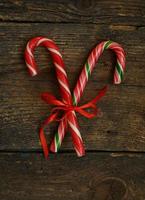 Closeup of two old fashioned candy canes on a rustic wooden background photo