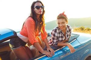 Two young girls having fun in the cabriolet outdoors photo