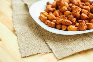 Cookies on a white plate on a sacking on a wooden background photo