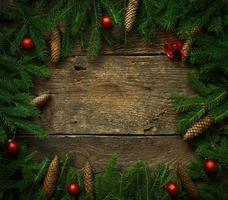 Christmas tree branches with cones and christmas decorations on wooden texture ready for your design photo