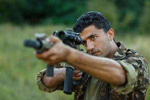 joven masculino soldado con máquina pistola foto