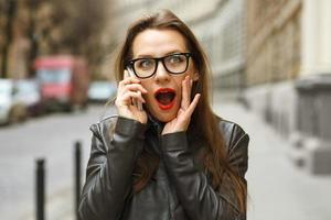 Surprised businesswoman talking on smart phone photo