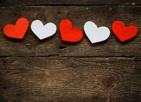 Red and white hearts on old shabby wooden background photo