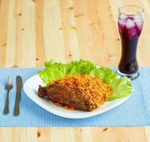 Tasty dishes from turkey meat with rice and salad leaves and a glass of juice with ice photo