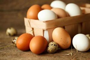 Chicken and quail eggs on a wooden rustic background photo