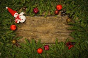 Christmas border with fir tree branches, cones and christmas decorations on wooden boards ready for your design photo