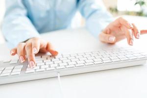 Woman office worker typing on the keyboard photo