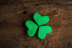 Green shamrock clovers on wooden background photo