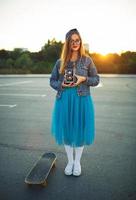 Summer lifestyle portrait of hipster girl with old camera photo