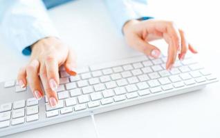 Woman office worker typing on the keyboard photo