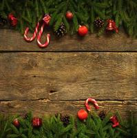 Christmas border with fir tree branches, cones, christmas decorations and candy cane photo