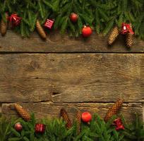 Christmas border with fir tree branches, cones and christmas decorations on wooden boards ready for your design photo