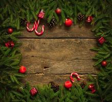 Christmas border with fir tree branches, cones, christmas decorations and candy cane photo