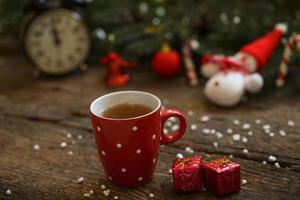 cerca arriba de té taza con Navidad decoración en de madera mesa foto