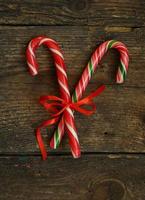 Closeup of two old fashioned candy canes on a rustic wooden background photo