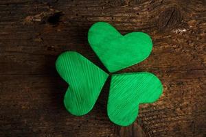 Green shamrock clovers on wooden background photo