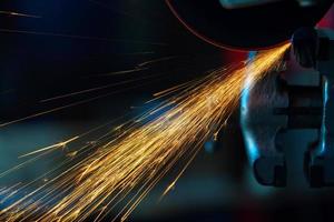 Angular grinding machine is cutting the metal and a lot of sparks photo